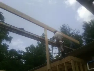 Carpenter setting a ridge beam over a new addition frame — Ice Dam Removal by Roofing Brothers in Dornsife