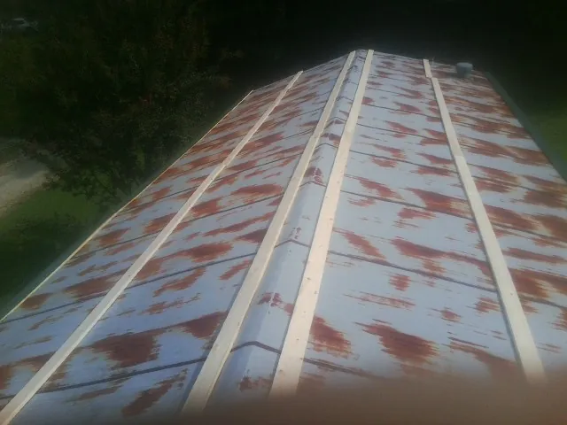 Rusted metal roof panels with new wood purlins before replacement — Storm Damage Roof Repair in Dornsife by Roofing Brothers