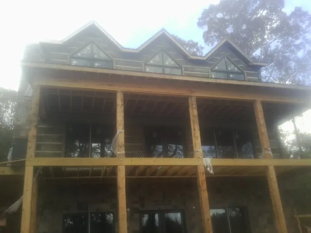 Dormers and porch framing on a large log home under construction — Roof Coating work by our crew in Dornsife
